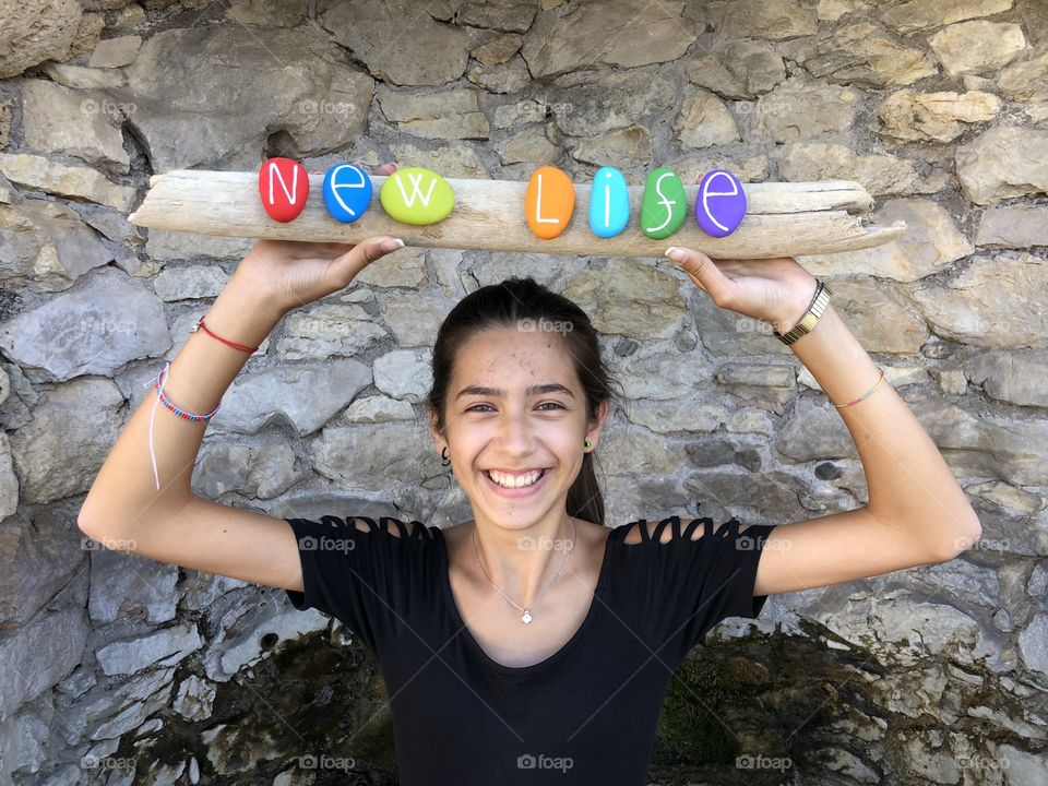 New life message with colored stones held by a young girl