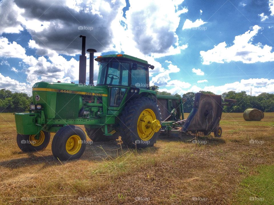 John Deere green . John Deere tractor and field of hay