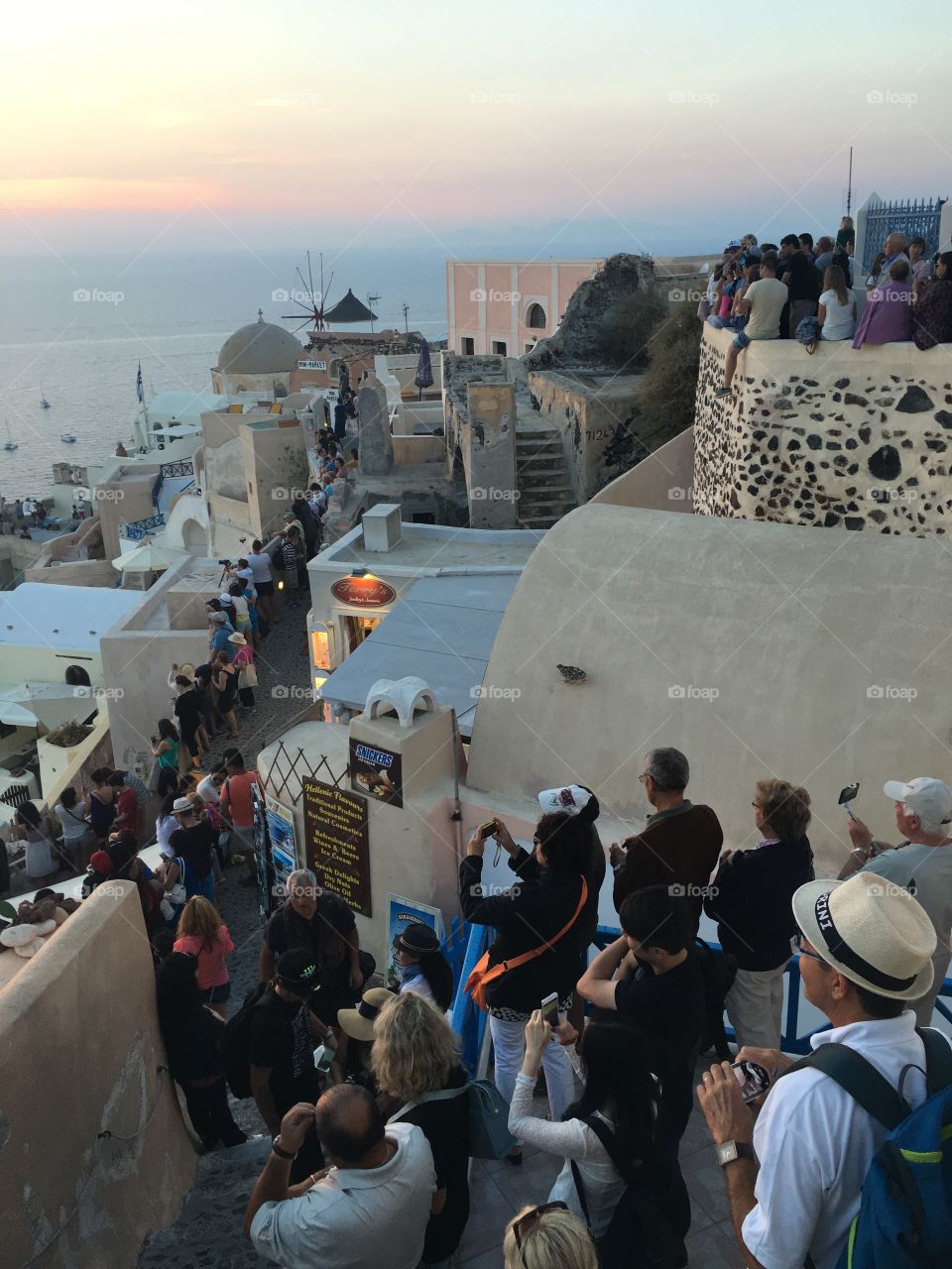 People admiring the sunset in Santorini Greece 
