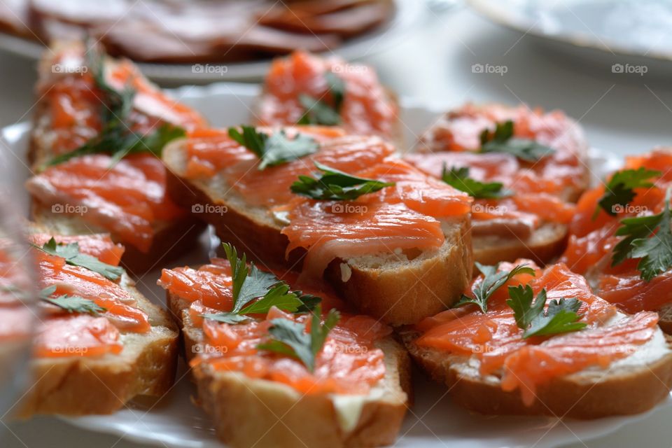 eating home sandwiches with red fish on a table