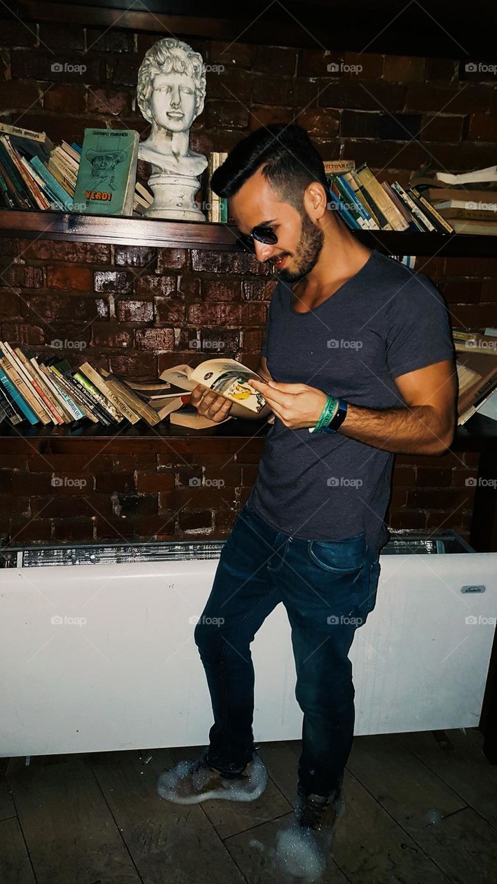 bearded man reading a book in the club