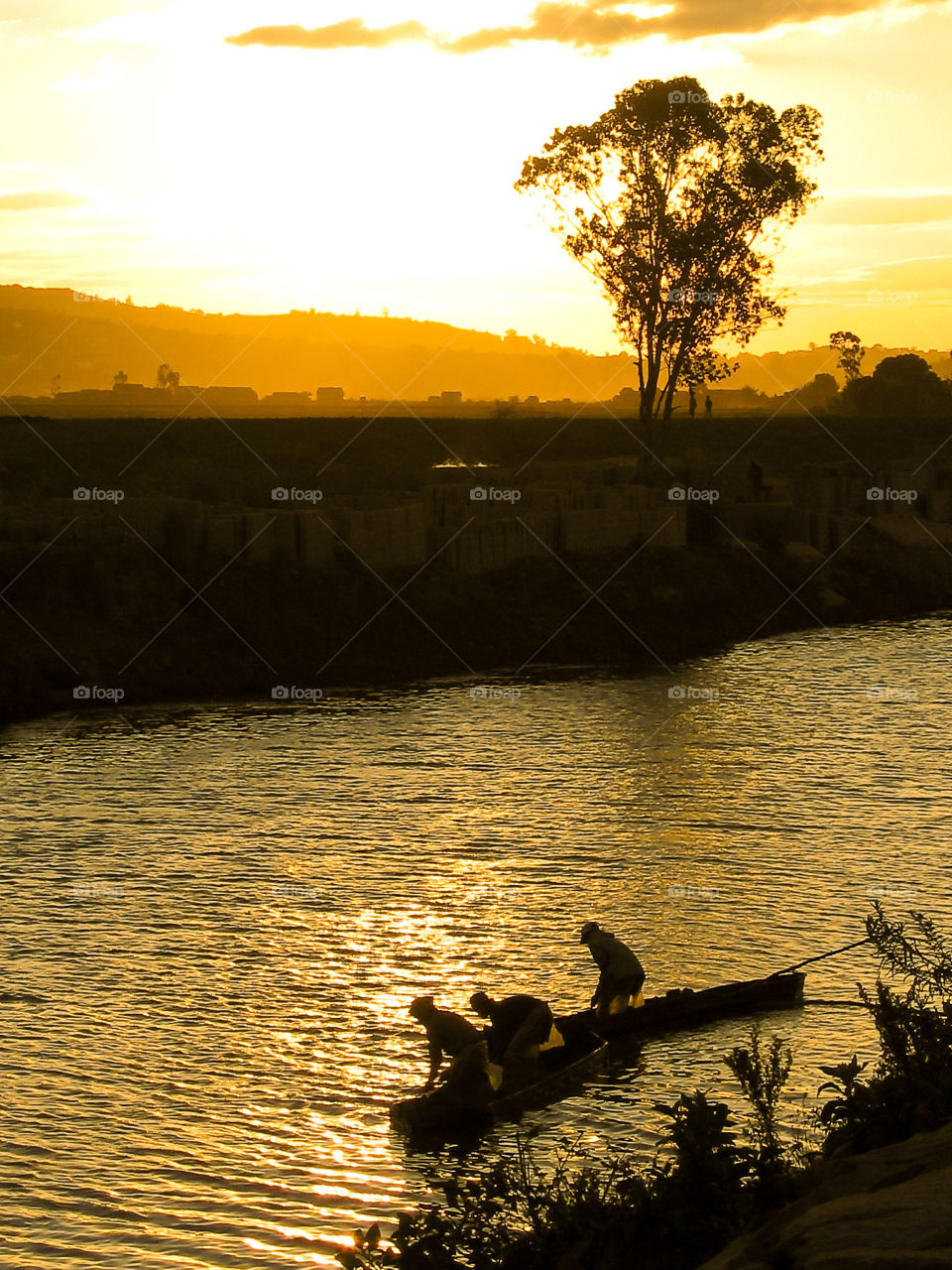 Going home after a day's work. People crossing the river after making bricks on the river shore. Image from Antananarivo Madagascar Africa