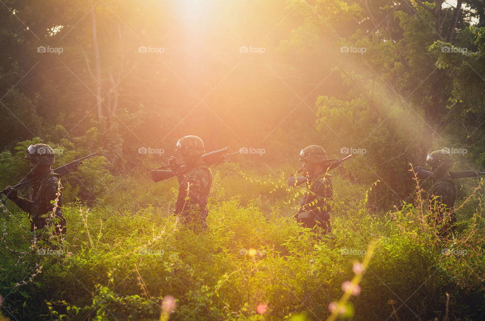 Soldiers with their gun in the jungle.