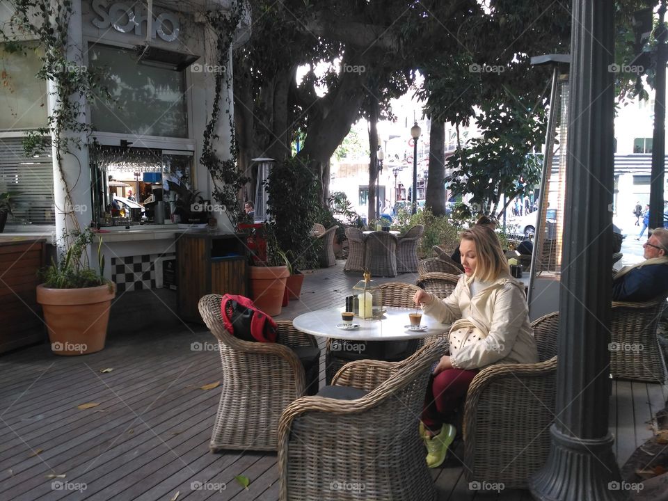 Woman suiting In cafe terrace drinking coffee