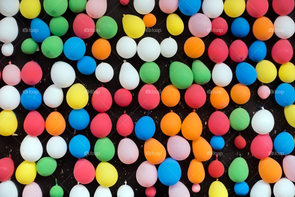 Colorful balloons hanging on black wall