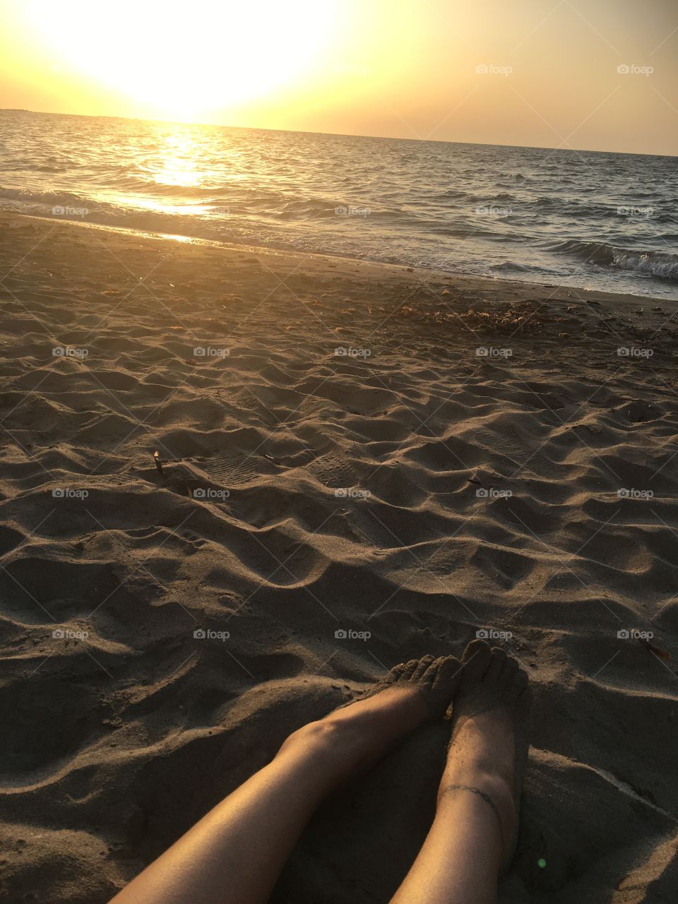 feet on the sandy beach of trapani, sicily, italy