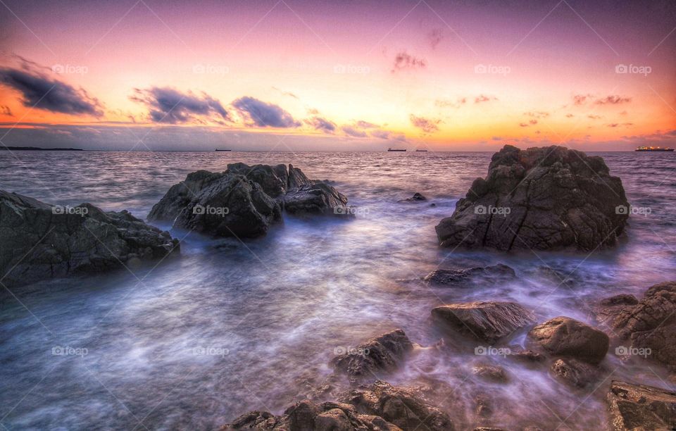 Blurred Ocean. An early morning sunrise with waves washing over rocks and a long exposure.