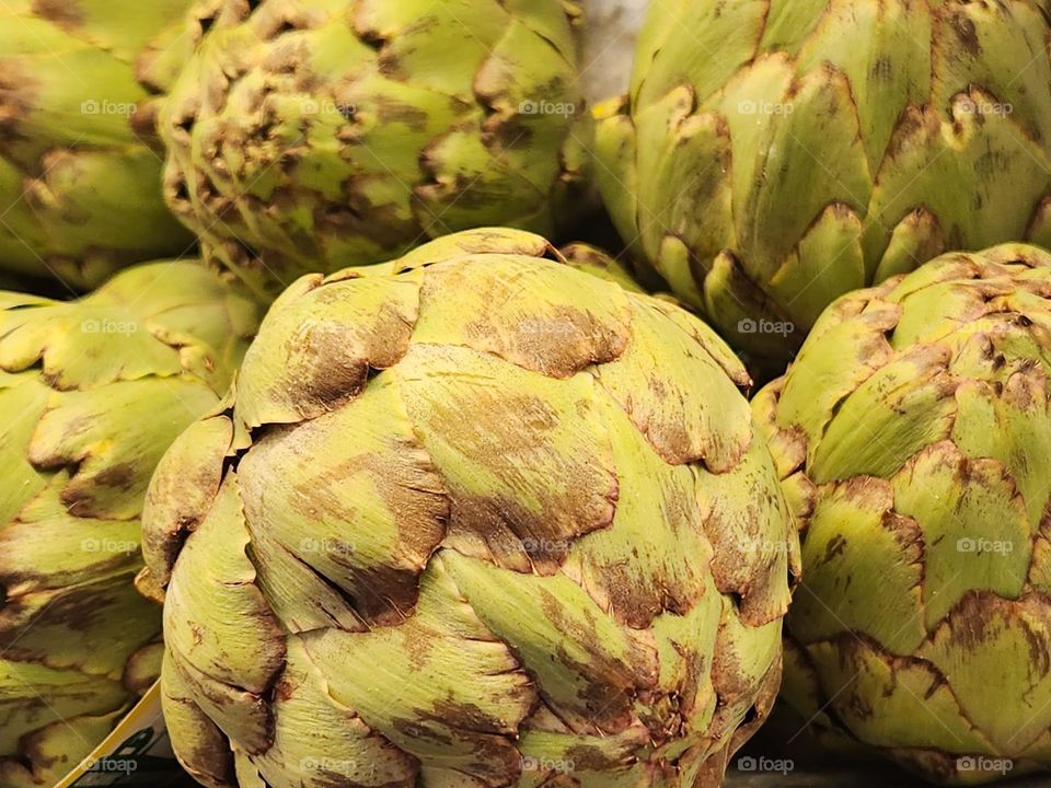 close up view of large green artichokes for sale in an Oregon market ready for a delicious meal