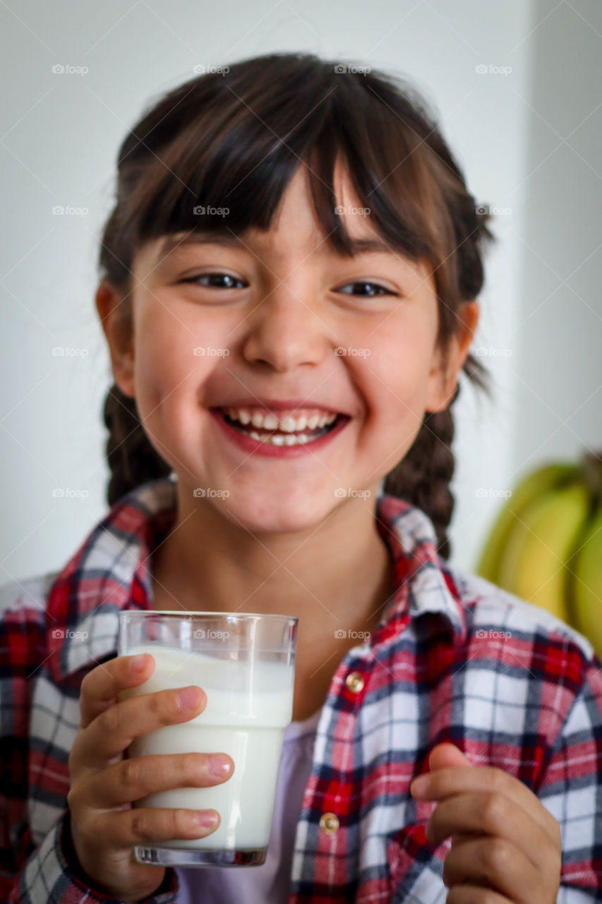 Cute little girl with milk in glass from ikea