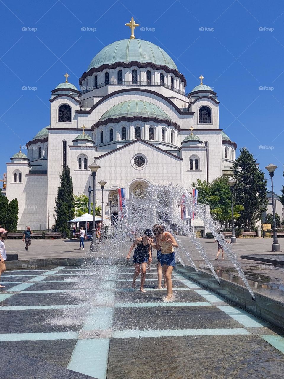 Children enjoy the fountain in the square in front of the temple of St. Sava, Belgrade