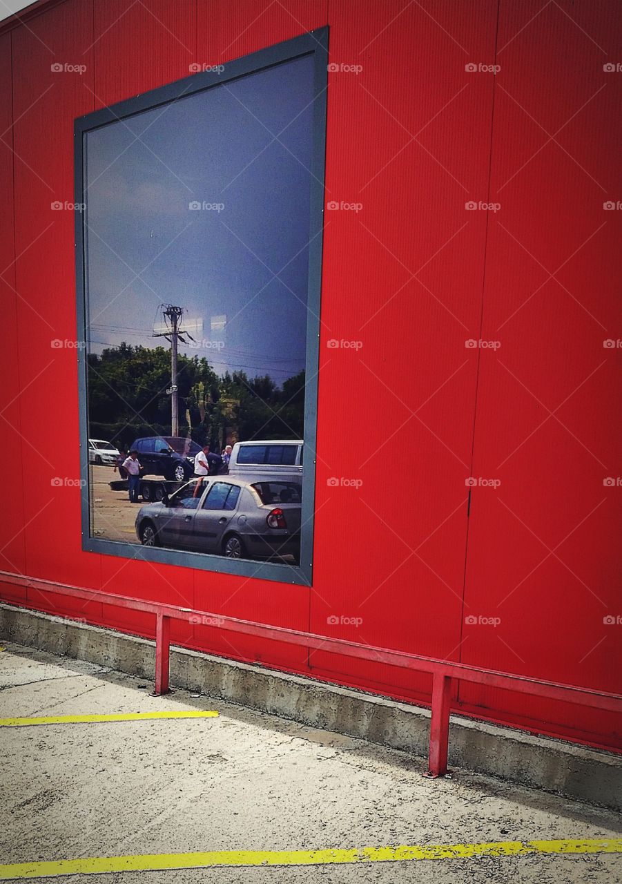Cars reflections in a window on red background