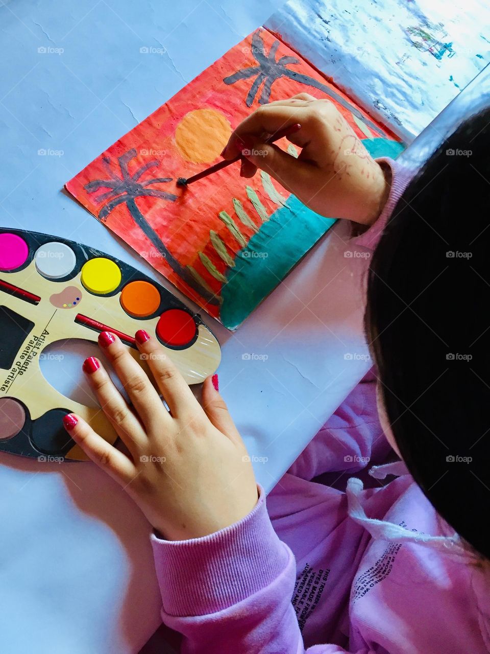 A little girl practicing her favorite hobby which is painting