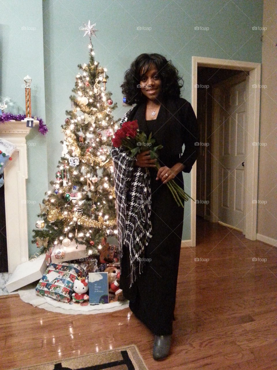 African woman standing in front of Christmas tree