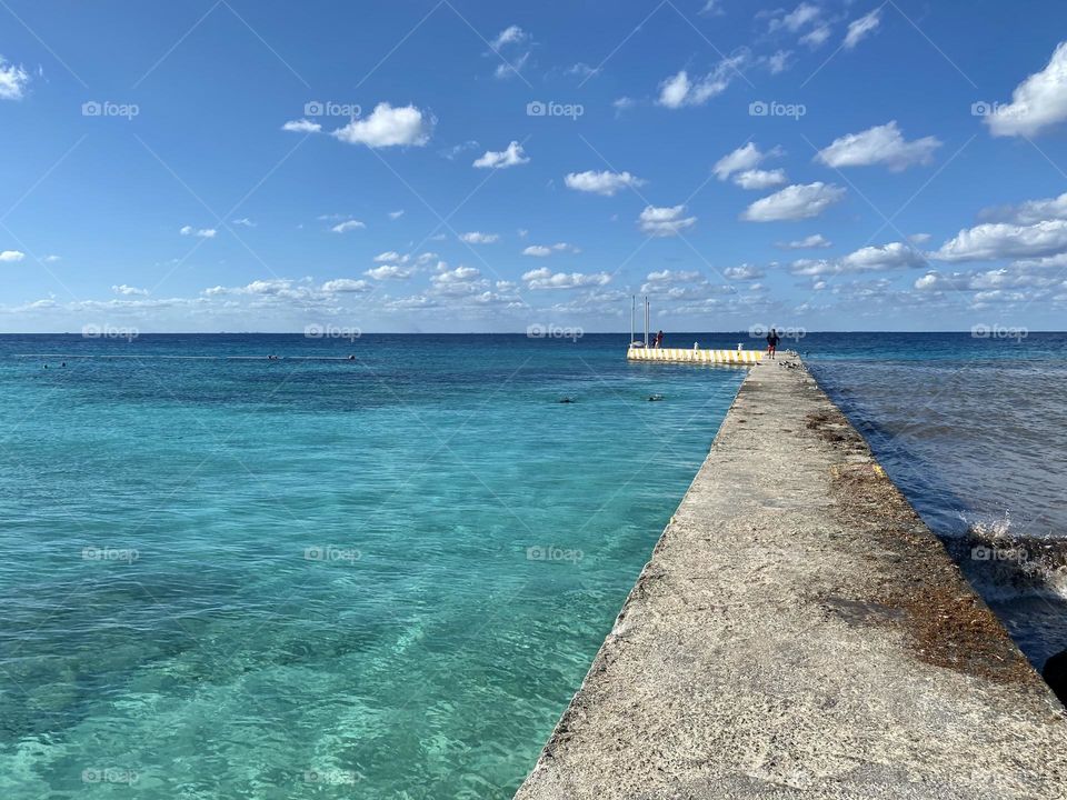 A pier with a lone person standing at the end