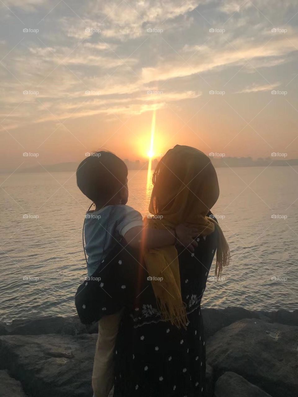 Mother and son on the sunset beach 