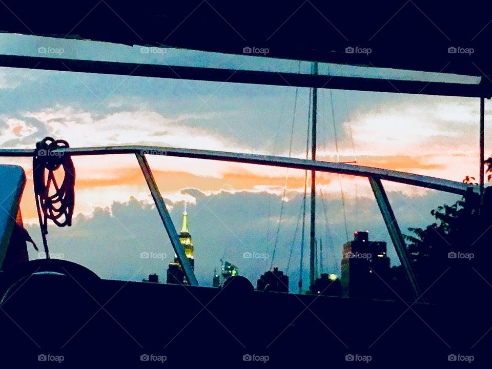 A view from aboard our sailboat, the “Salvation” in Newtown Creek, LIC, Queens, NY one evening in 2018 in the twilight time of dusk after the sun had set. In the distance you can see the Manhattan skyline and the Empire State. Hypnotic Productions