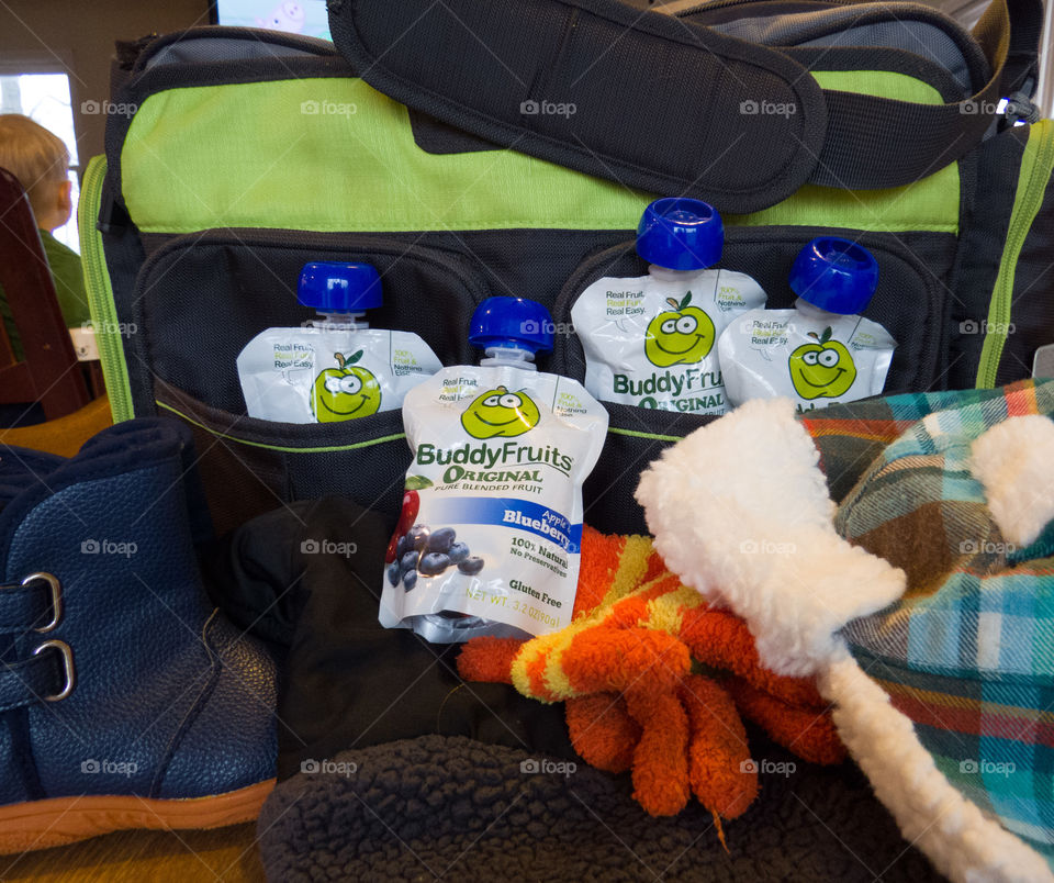 Buddy Fruits with a diaper bag and winter items.