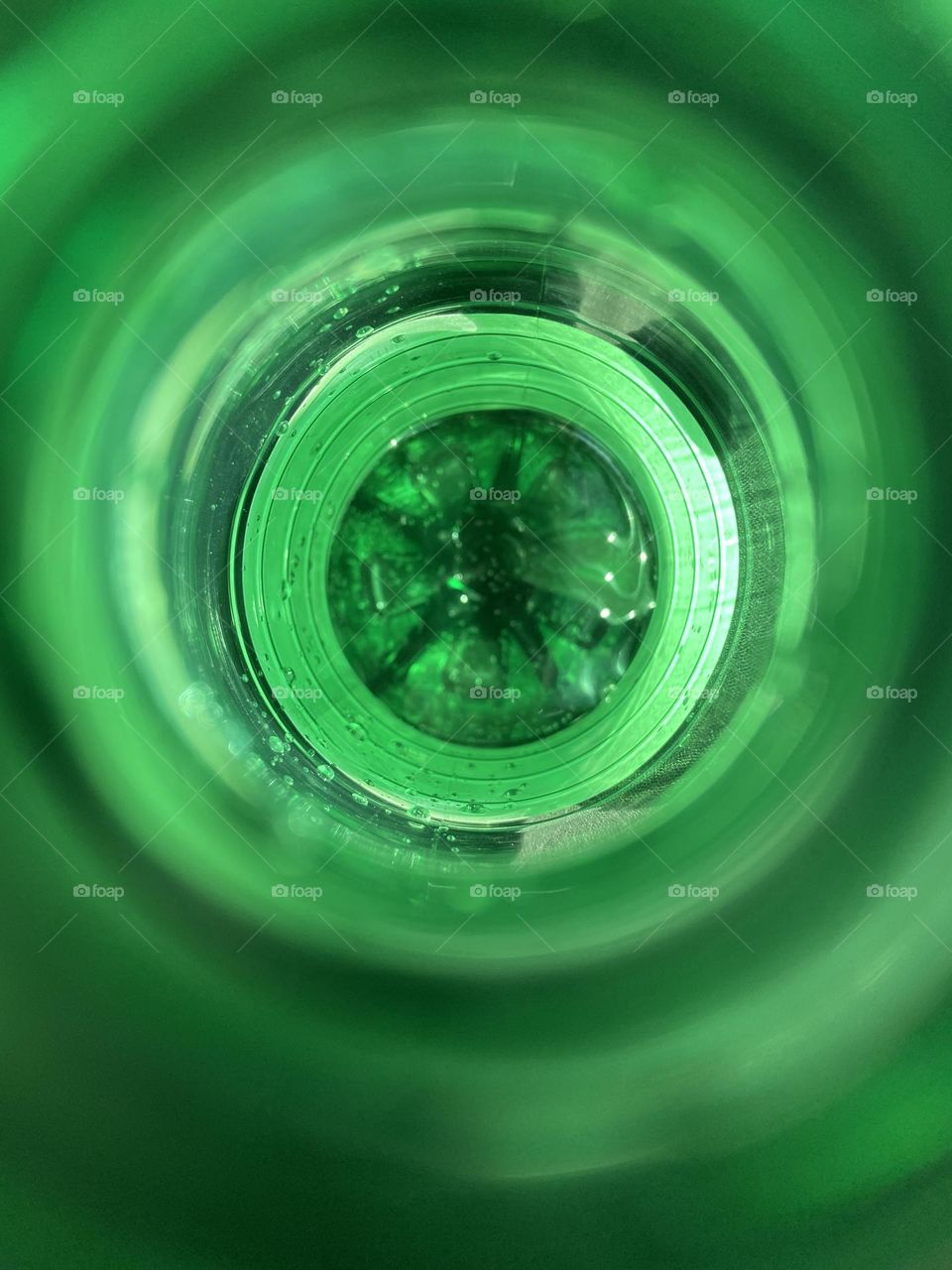 Looking into the top of a green bottle of San Pellegrino sparkling water. The rim of the bottle makes a green circular pattern of varying shades that is simply beautiful, and the water is a darker focal point in the center. Art is everywhere. 