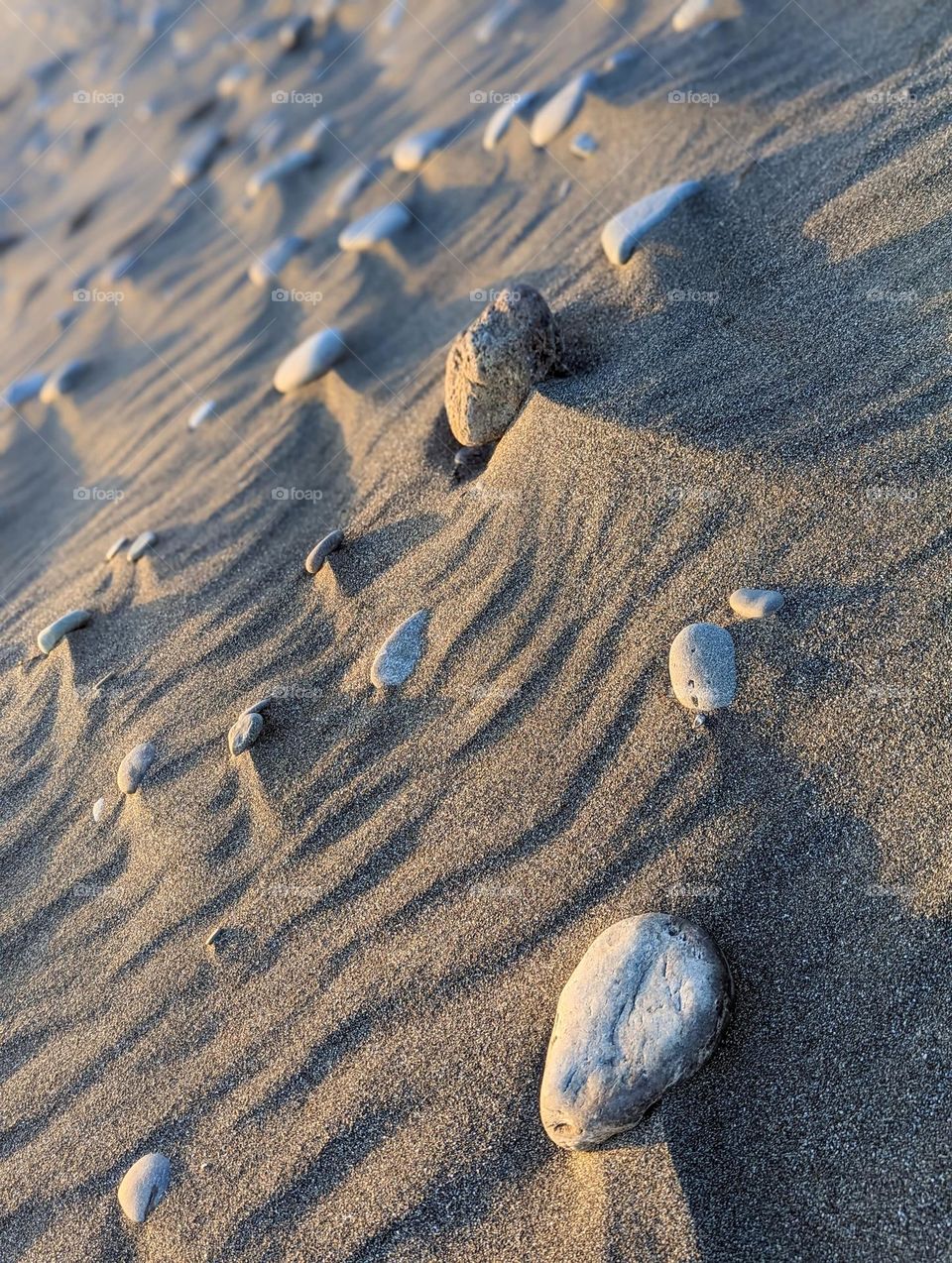 ocean beach rocks sandy zen stones by the ocean smooth beach rocks windy lines in the sand