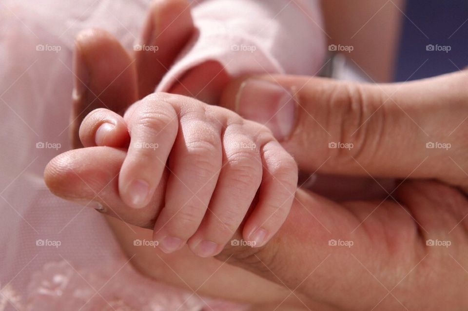 Proud and loving father holds his newborn baby hand