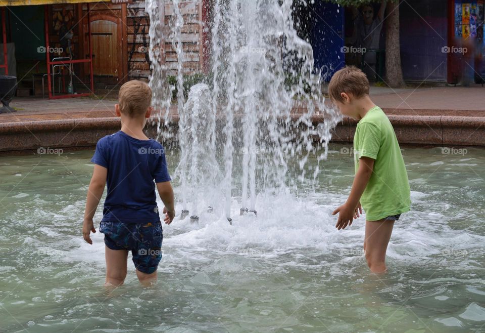 children in water fountain urban nature summer time