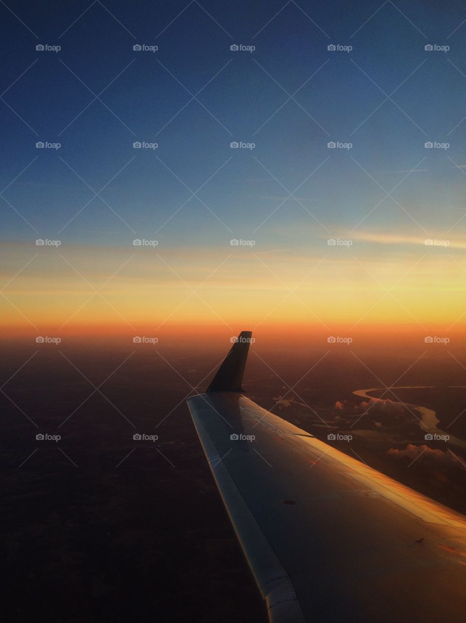 Airplane wing with sunset over Ohio River. Flying into the sunset over the Ohio River Valley