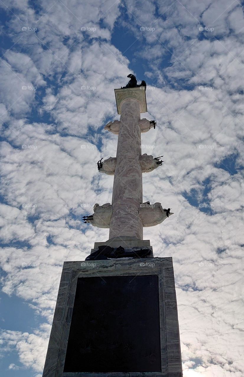 Column on a cloudy sky background