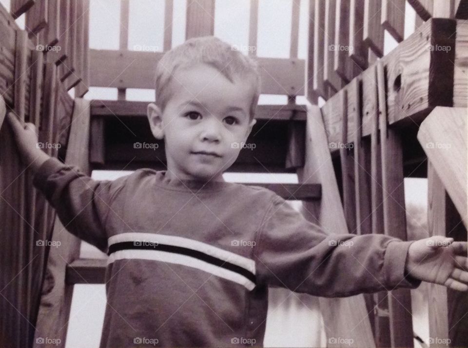 Boy on wooden play set sepia
