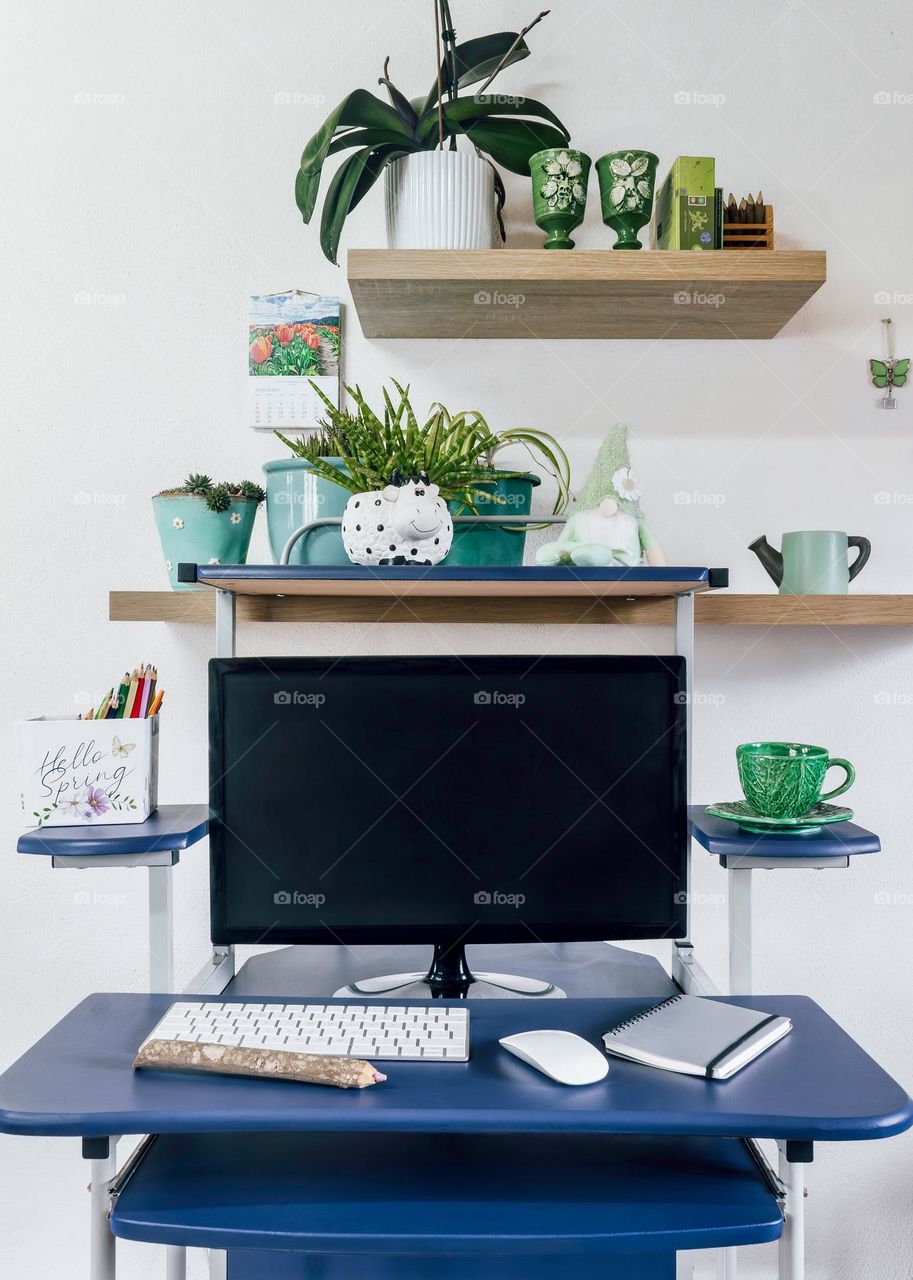 A desk with a springtime feel, with plants and greenery