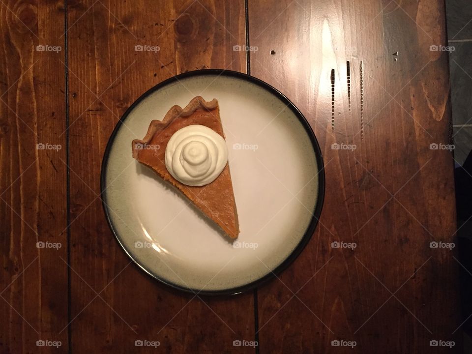 Perfect slice of homemade pumpkin pie with homemade whipped cream 