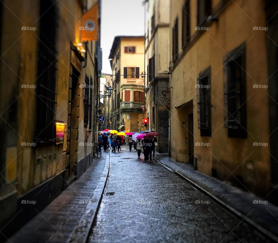People with umbrellas on a rainy afternoon in Florence, Italy 