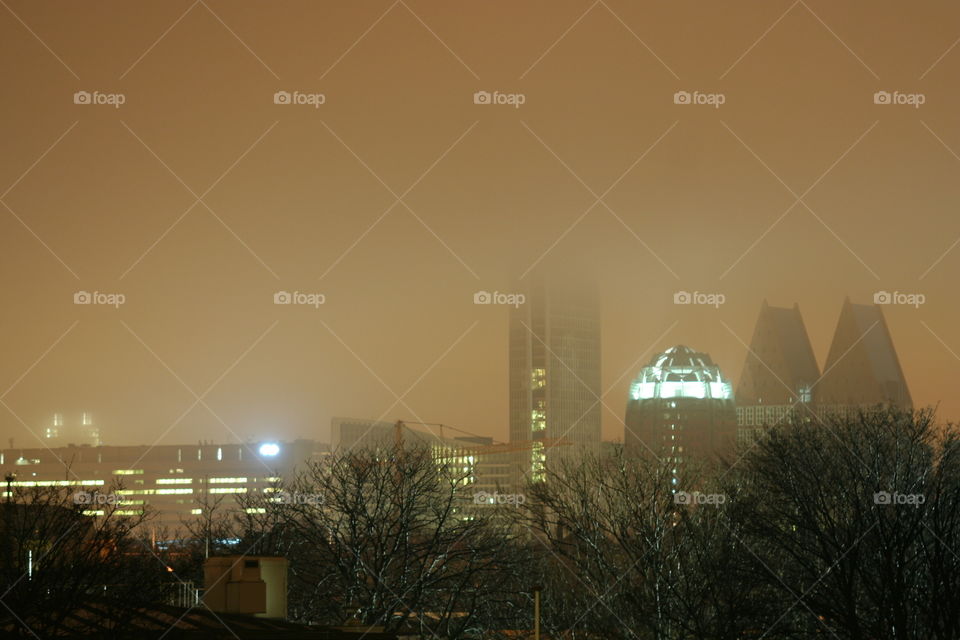 Skyline of The Hague in the mist at night.