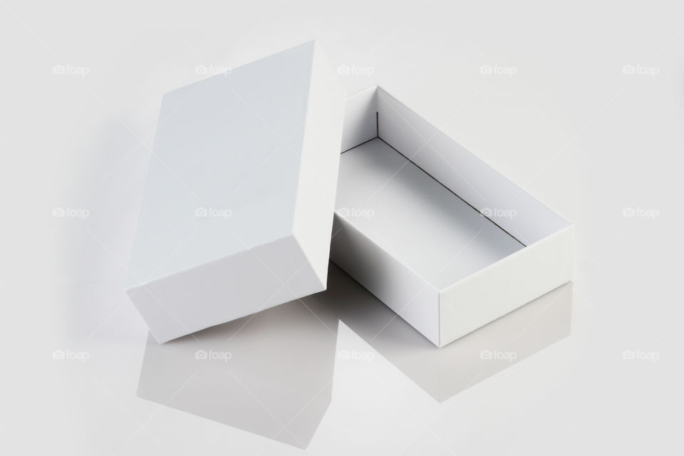 Open white box on white reflective background