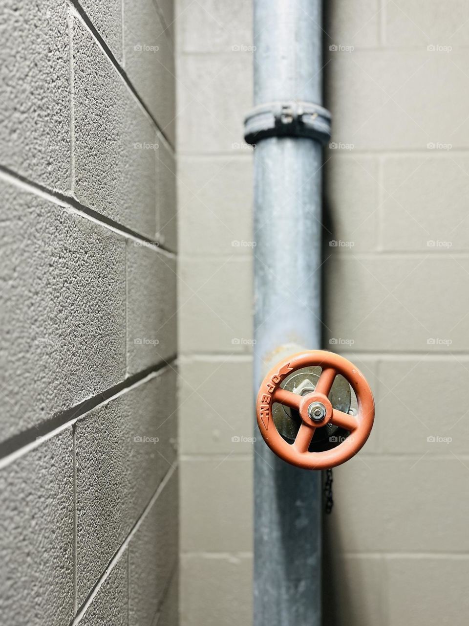 Safety system in a concrete stairwell. Closeup on water pipe and valve used to fight fire.