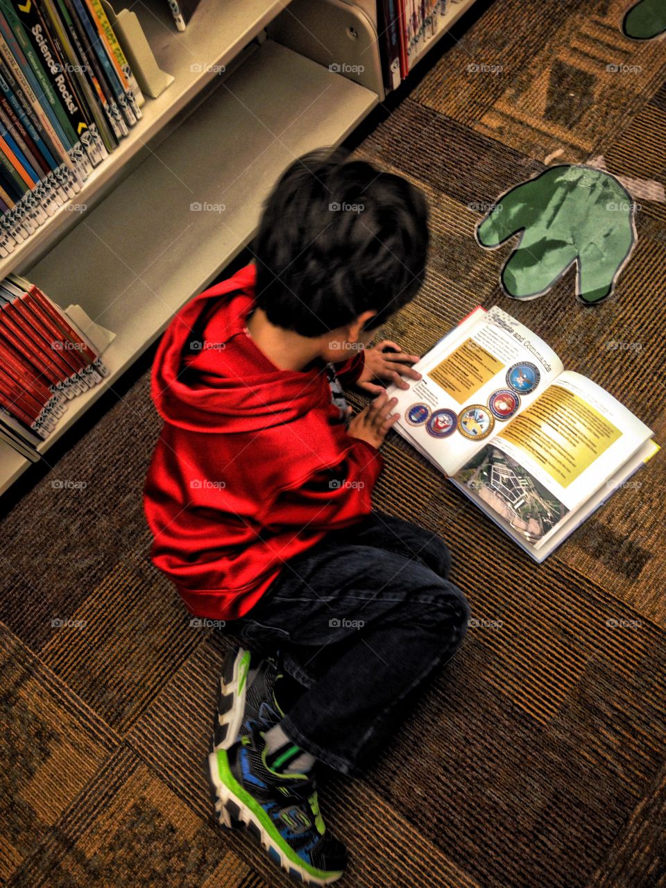 The pursuit and innocent passion . My son reading a book in the library...