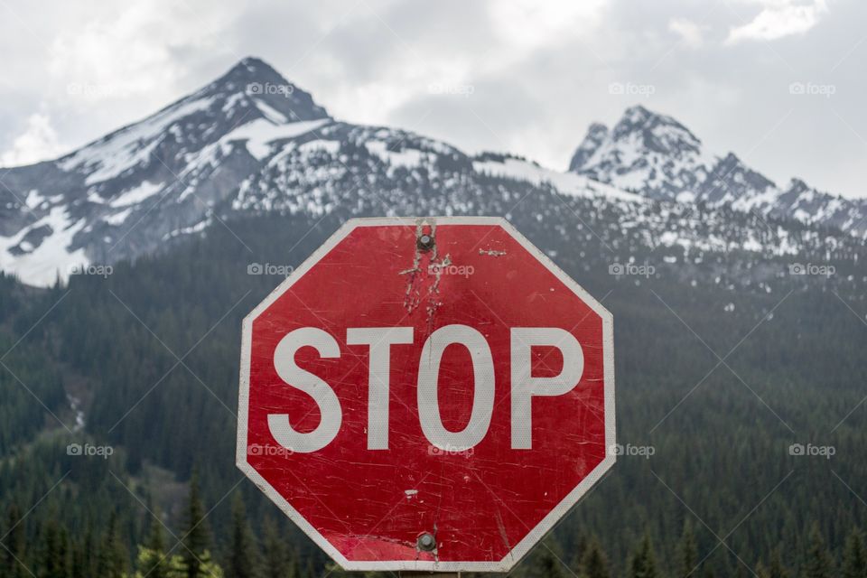 Red stop sign with Rocky Mountain background 