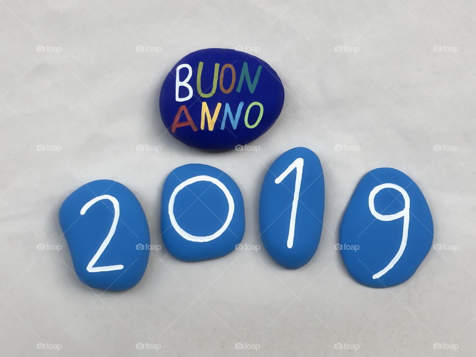Buon Anno 2019, italian Happy New Year 2019 with colored stones over white sand