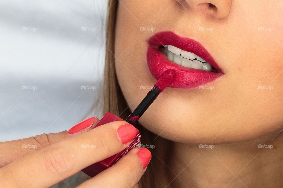 Woman applying red lipstick 