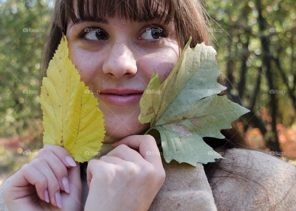 Portrait of Smiling Young Girl on Autumn Background