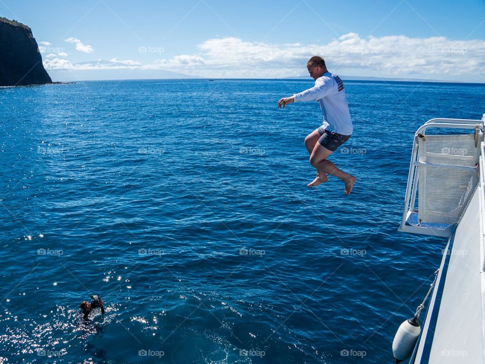 Pure joy and excitement jumping off a charter boat into the warm waters of the Pacific Ocean in Hawaii