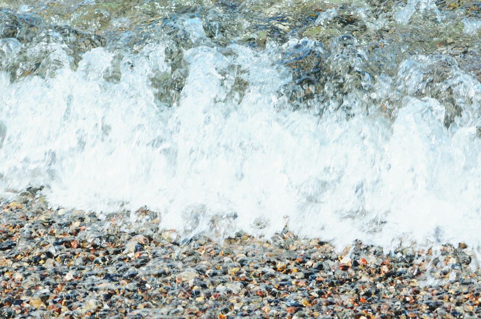 waves running over pebbles on beach.