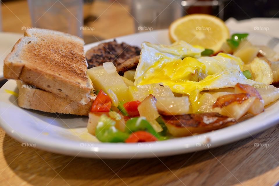 Delicious  Skillet Potatoes,sausage toast,and eggs on a plate