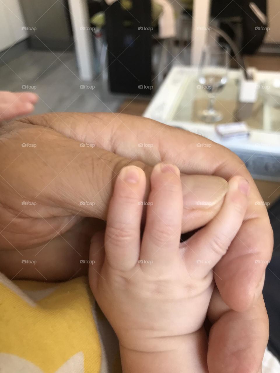 baby's little hand in grandfather's hand, different generations