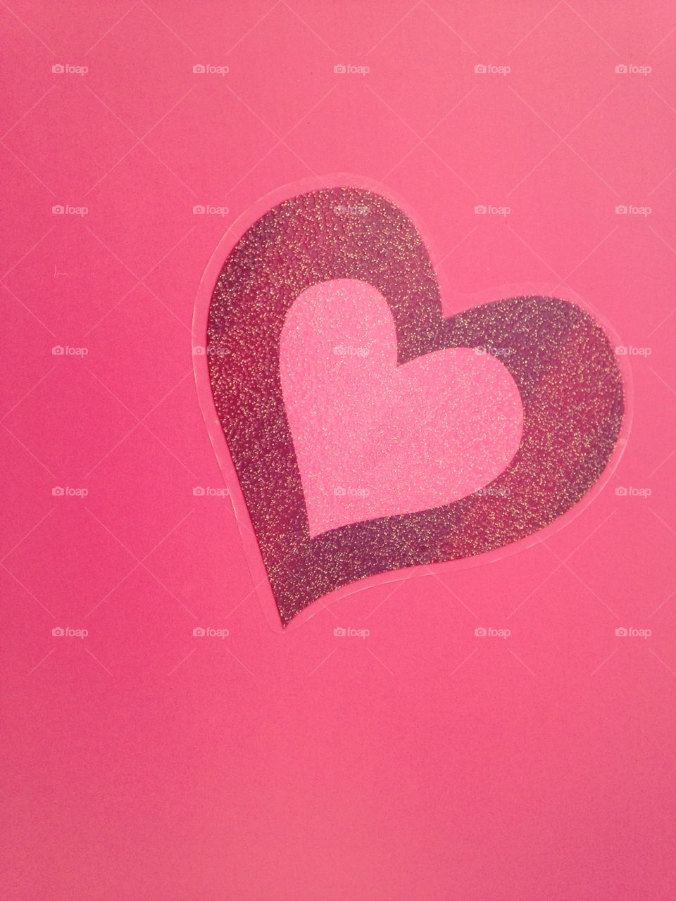 Glitter heart shape on pink background