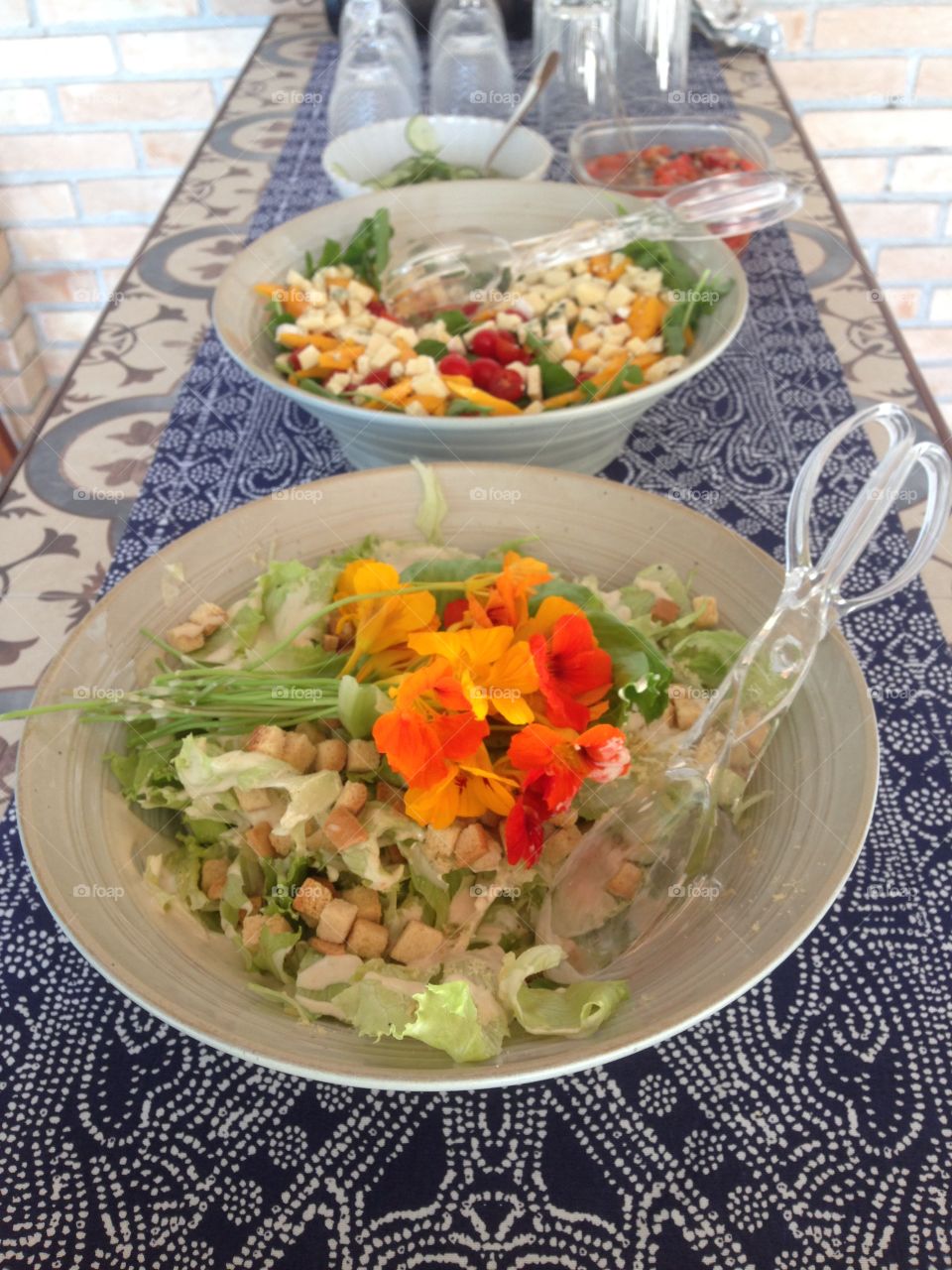 a delicious ceasar salad with capuchinha flowers and green  leaves
