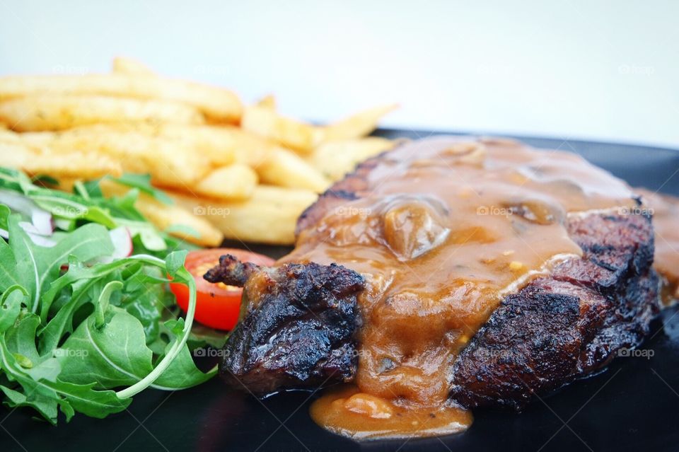 Steak with sauce and fries