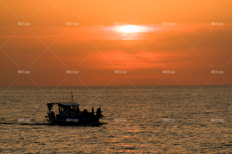 boat sailing at sunset