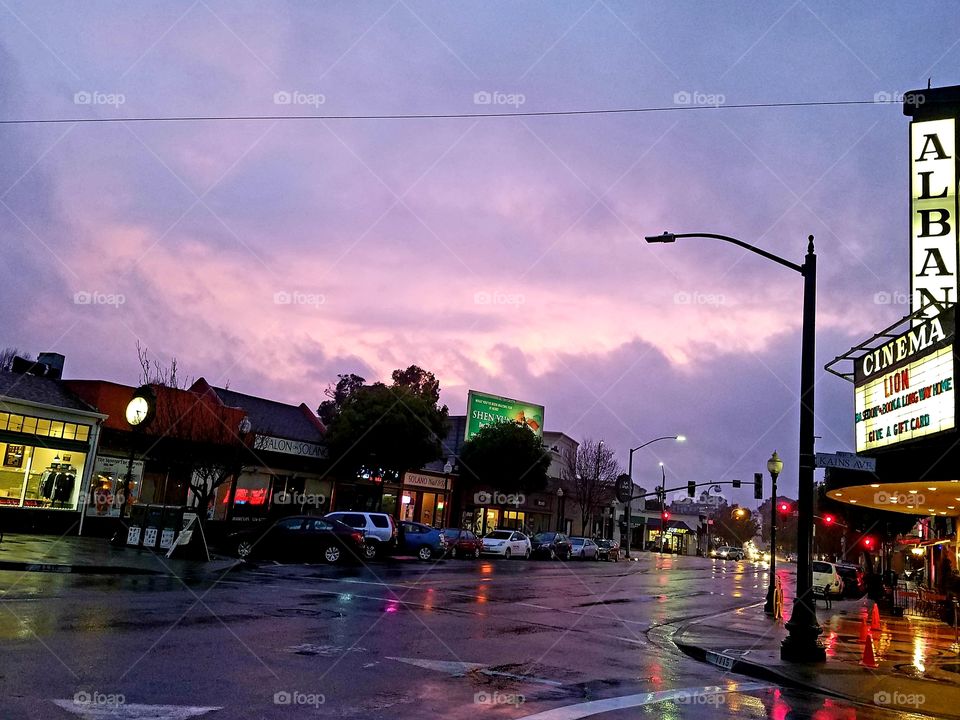A purple sky behind a rain slicked street
