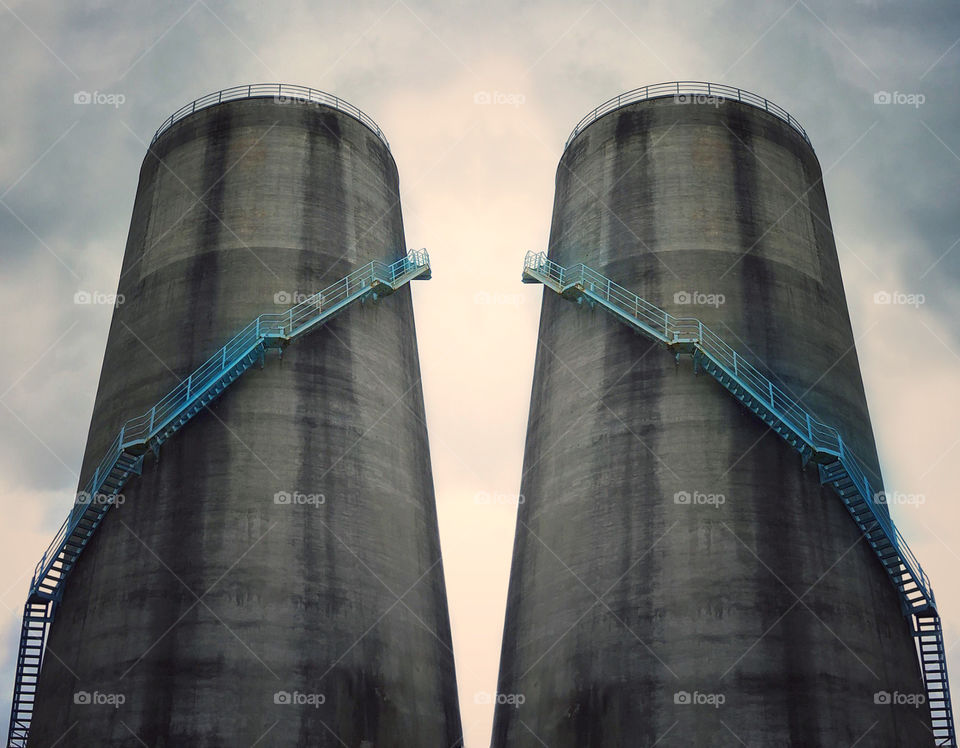 Twin silos with metal staircases wrapping around their exteriors 