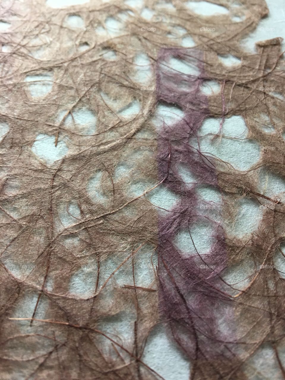 Purple strand through handmade paper 